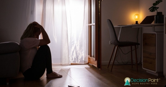 Girl sitting on floor with her head in her hands